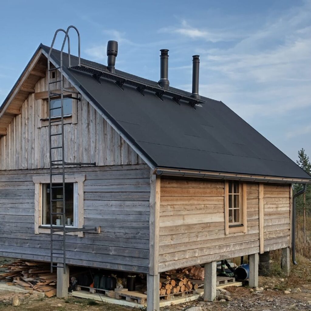 Kuvassa hirsimökki, eräkämppä kesällä