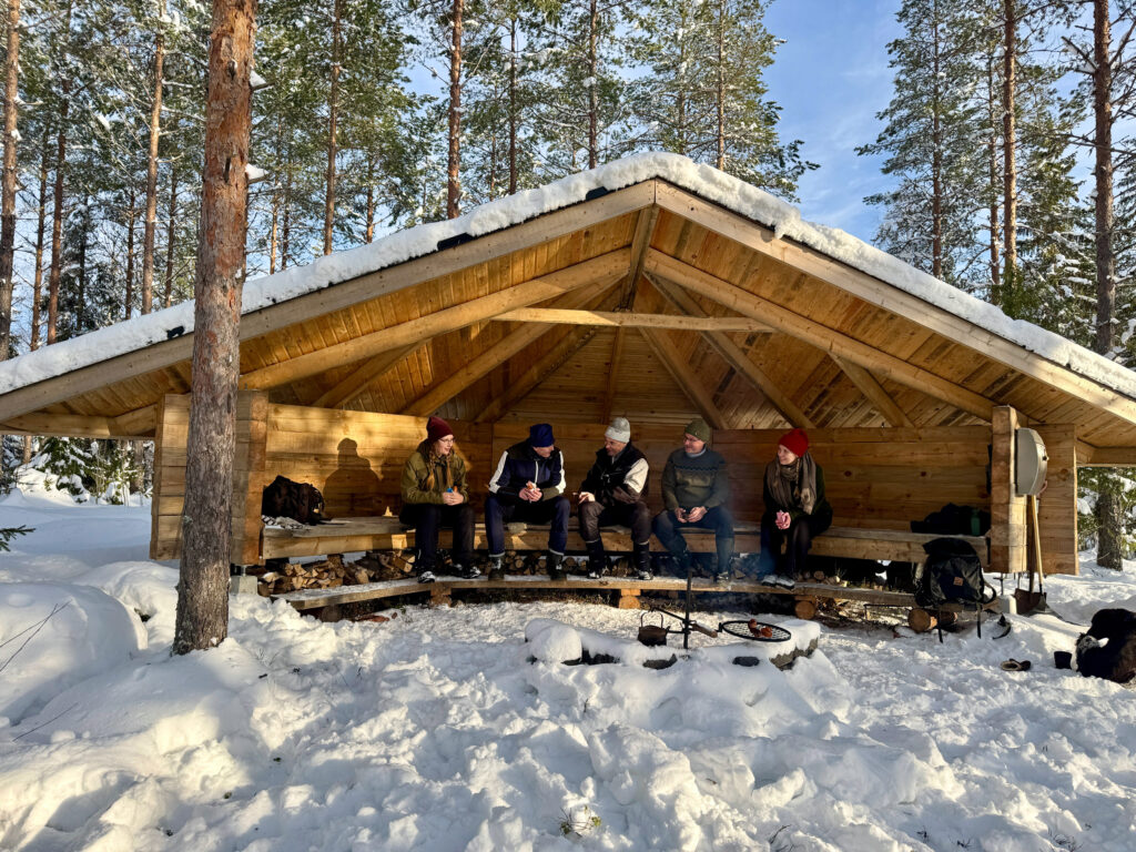 Ulkoilijoita istumassa LockCornerin laavulla